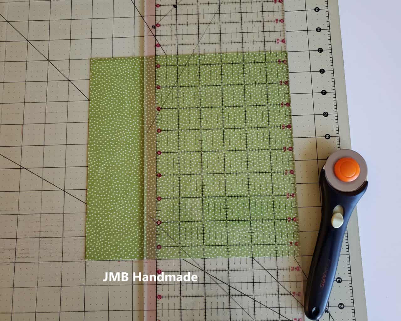 Cutting mat, clear ruler and rotary cutter to cut zippered pocket fabric
