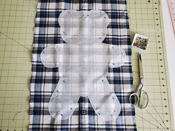 Large bear template pinned to shirt, ready to cut