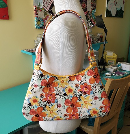 Finished curved top shoulder bag displayed on dress form