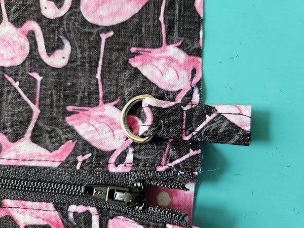 Short strap with D ring basted to outer fabric of wristlet