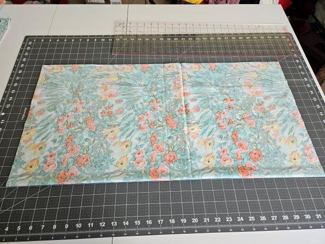 Fold the large fabric piece in half