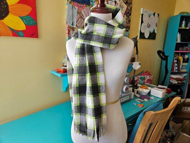 Flannel scarf with fringe over shoulder