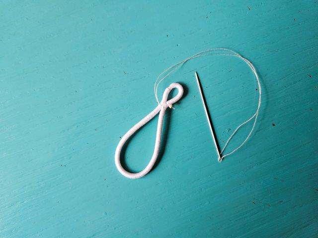 Pinch hair tie and hand-sew to keep pinched