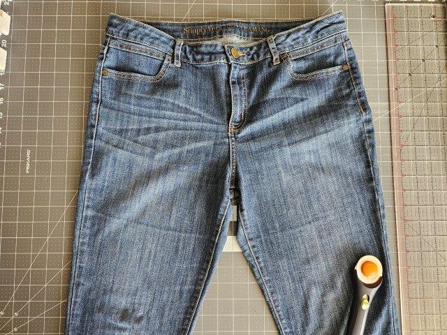 Jeans placed on table ready to cut