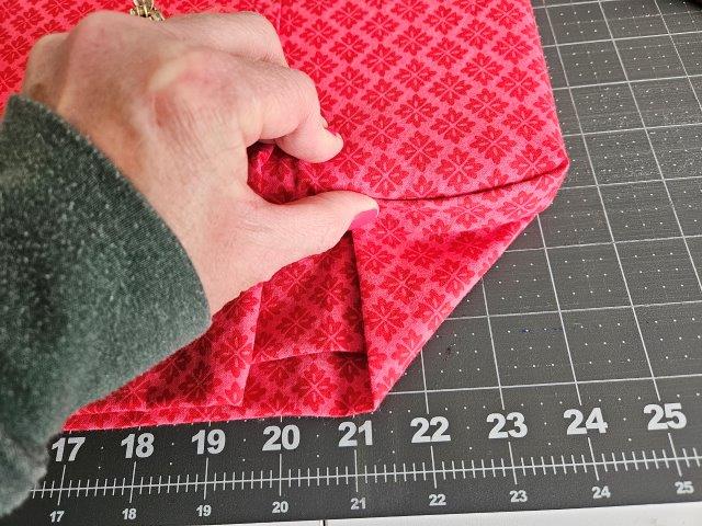 Fold over each corner of fabric like wrapping a present