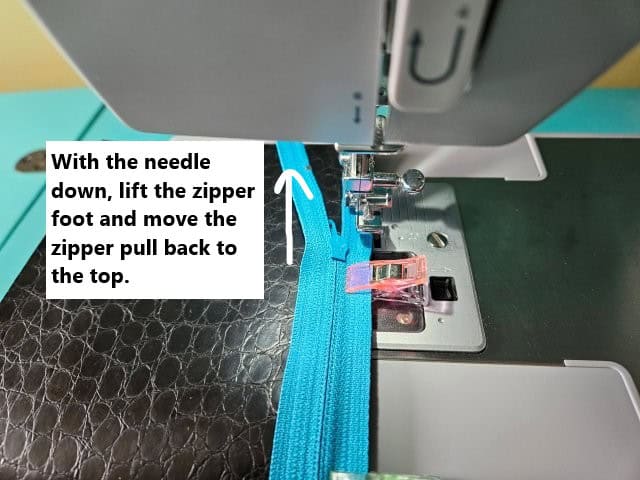 Lift the zipper foot and move the zipper back to the top