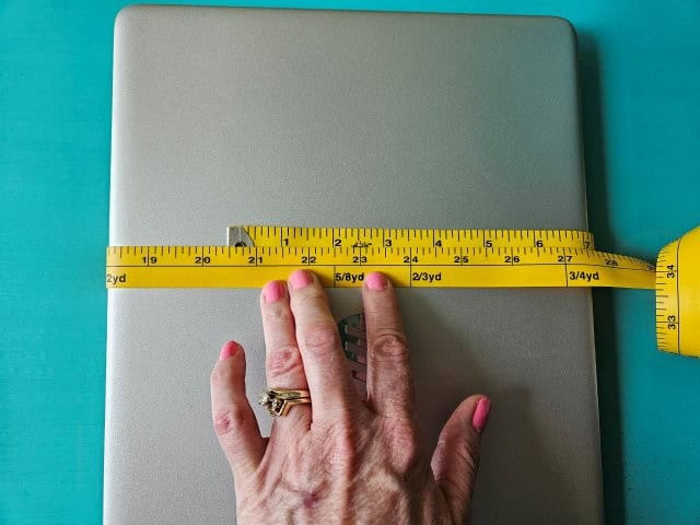 Wrap measuring tape around laptop to measure length