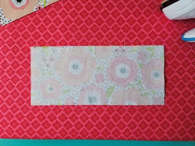 Place the laptop bag strap face down on ironing board