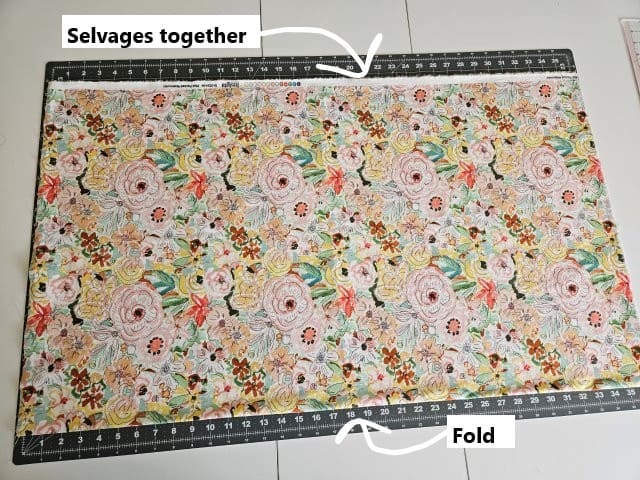 Fold fabric in half with selvages together