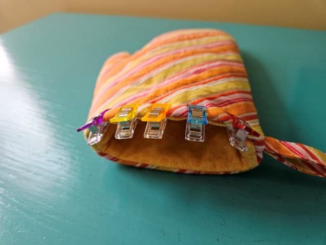 Fold in the opening and top stitch around the bottom of the mitt