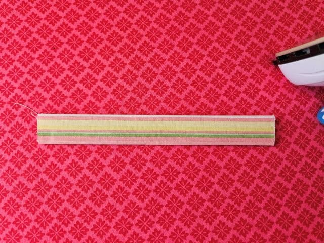 Fold the strap in half again and press