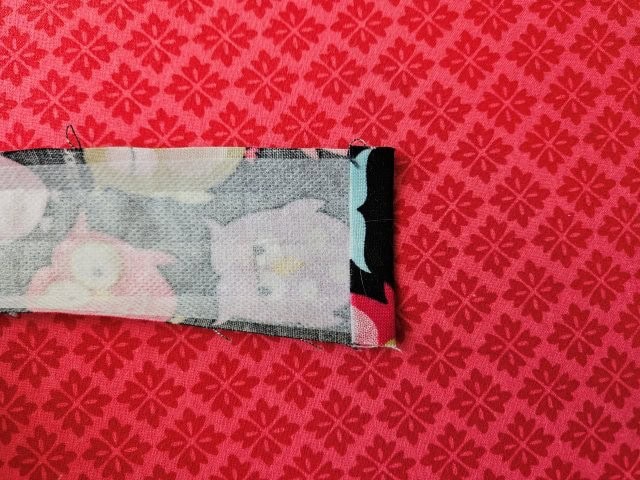 Hem the long strap and press