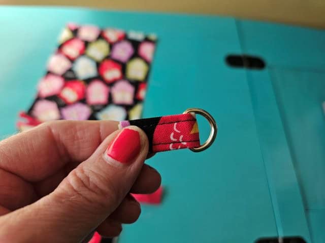 Slide short strap through D-ring and fold over