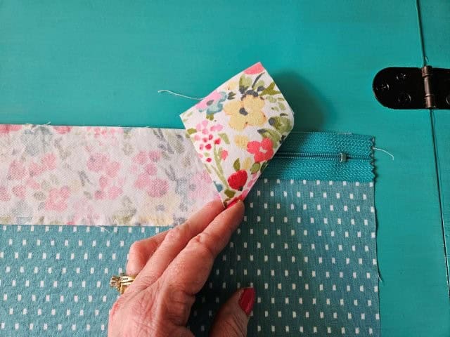 Recessed zipper outer fabric on top of zipper