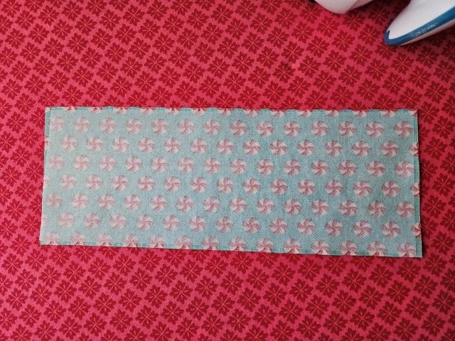Strap fabric piece face down on ironing board