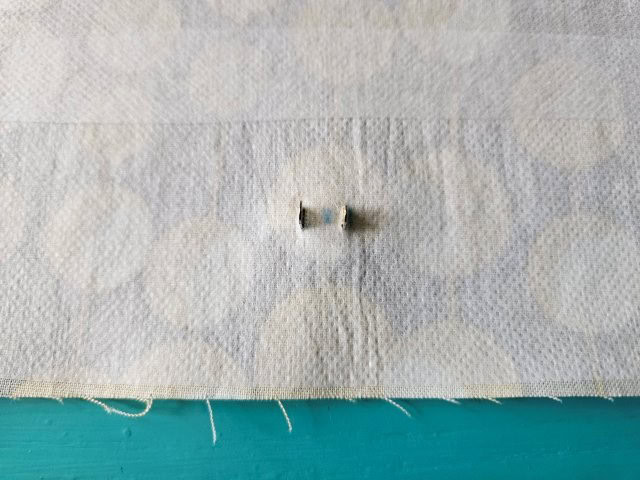 Push the prongs through the slits