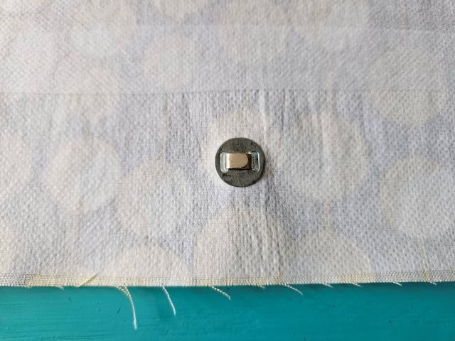 Add washer and bend the prongs on the snap