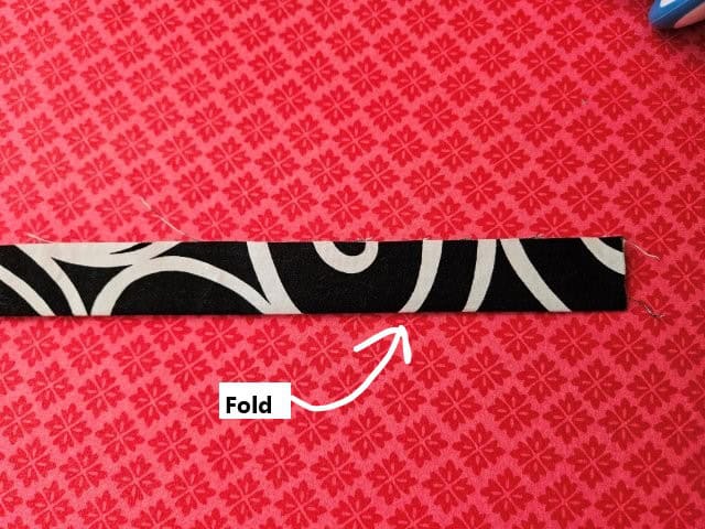 Fold the strap in half lengthwise and press
