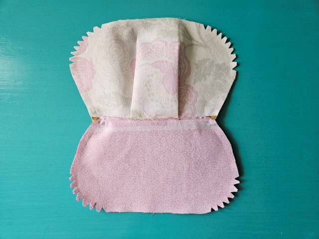 Cut little triangles around the curves and trim the zipper