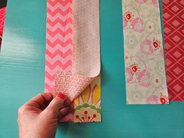 Third fabric strip on top of the second fabric strip right sides together