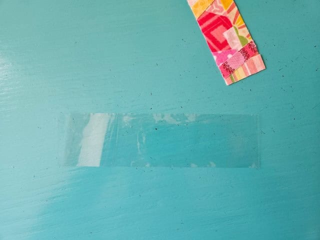 Cut a piece of packaging tape longer than the bookmark