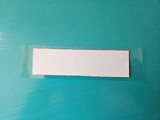 Place the bookmark face down onto the tape