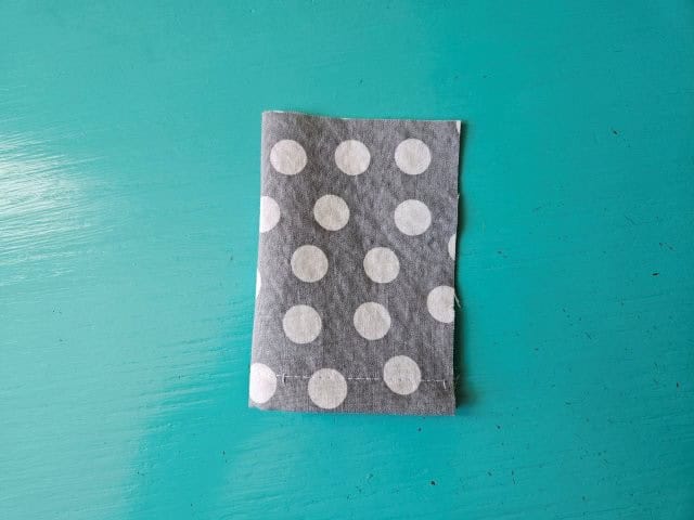 Fold the small fabric piece in half lengthwise
