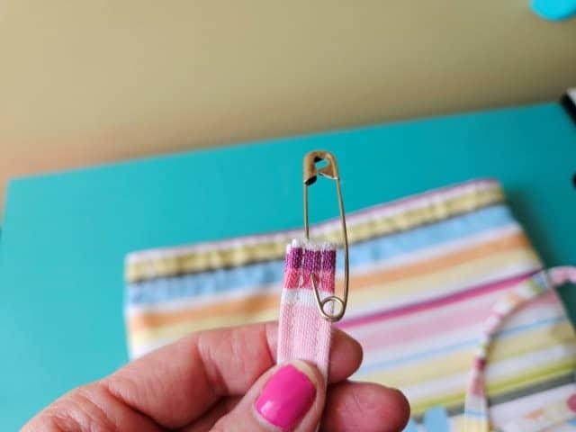 Weaving the strap through the shower curtain holes