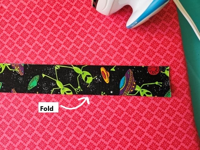 Fold the bag strap in half lengthwise, wrong sides together
