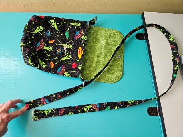 Slide the end of the strap through the left rectangle ring