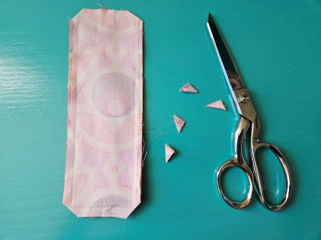 Clip the corners of the elastic pen holder using sewing scissors