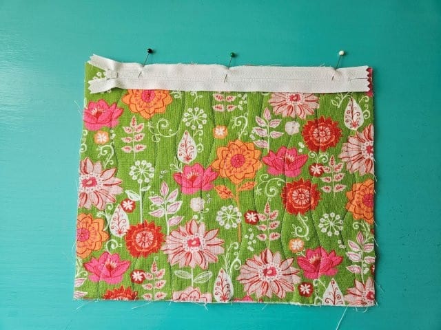 Place zipper face down on front outer fabric piece