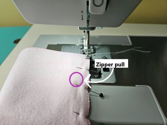 Begin sewing the zipper and stop at the zipper pull