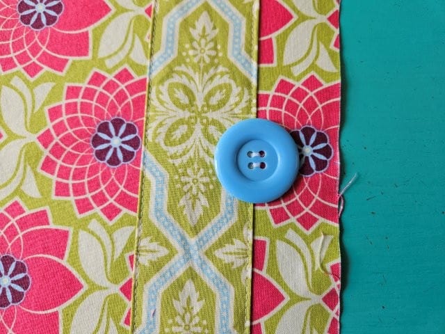 Sew the button by hand to secure to the notepad holder