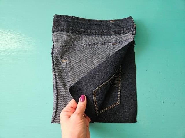 Fold the jeans in half right sides together, lining up the raw edges.