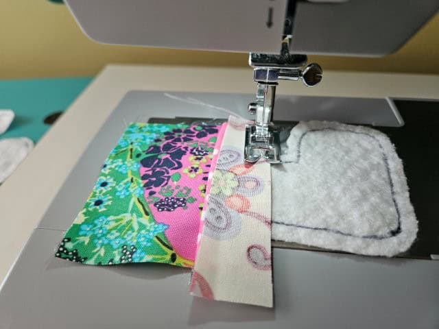Place a third fabric piece of the second and sew along the bottom