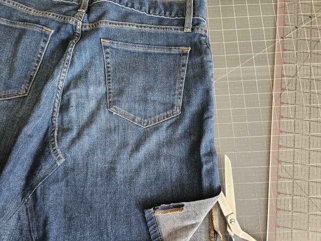 Cut along the outside seam of the jeans