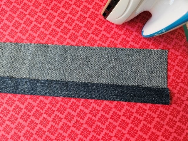 Open up the strap and fold one side to center