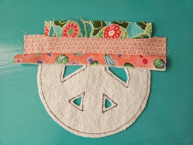 Third fabric strip attached to the peace sign
